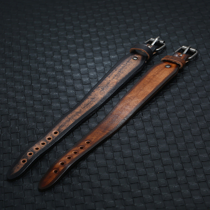 Two leather straps on a textured black surface