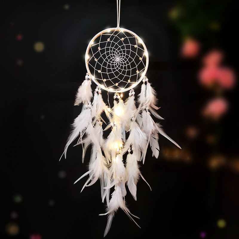 Decorative dreamcatcher with feathers and LED lights on a dark background