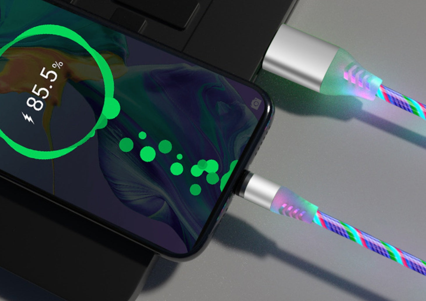 Smartphone with charging cable and colorful LED lights on a gray surface