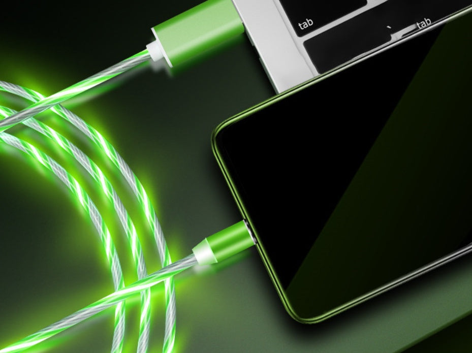 Green fiber optic cable being plugged into a smartphone on a dark surface