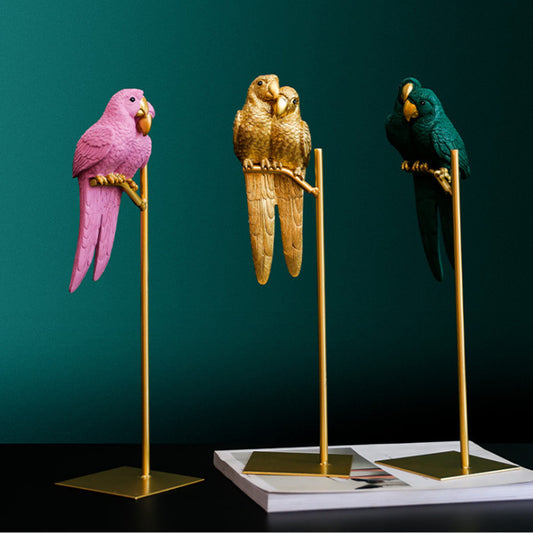 Three parrot figurines on stands against a dark green background
