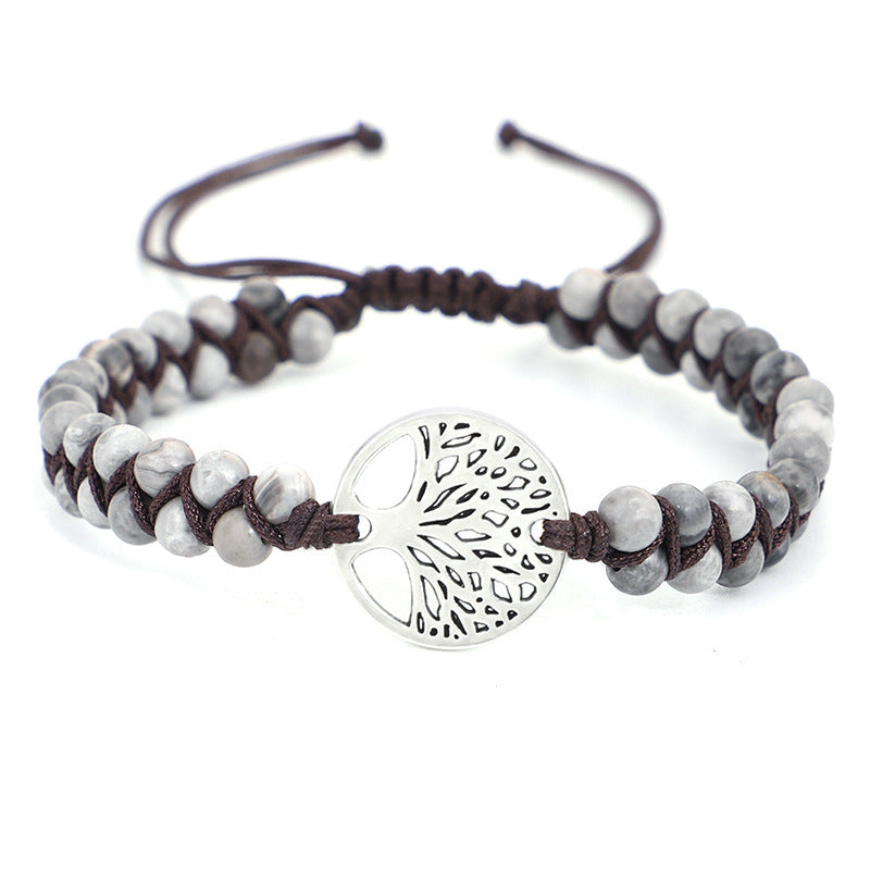 Bracelet with gray beads and a silver tree-of-life charm on a white background