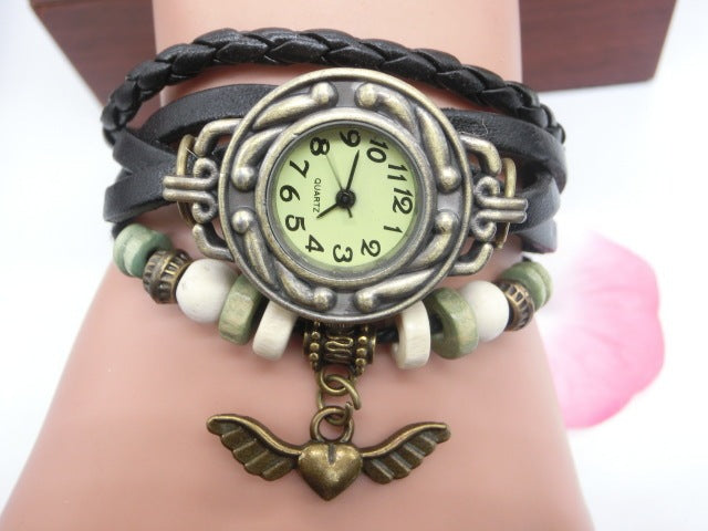 Bracelet watch with braided design and heart pendant on wrist
