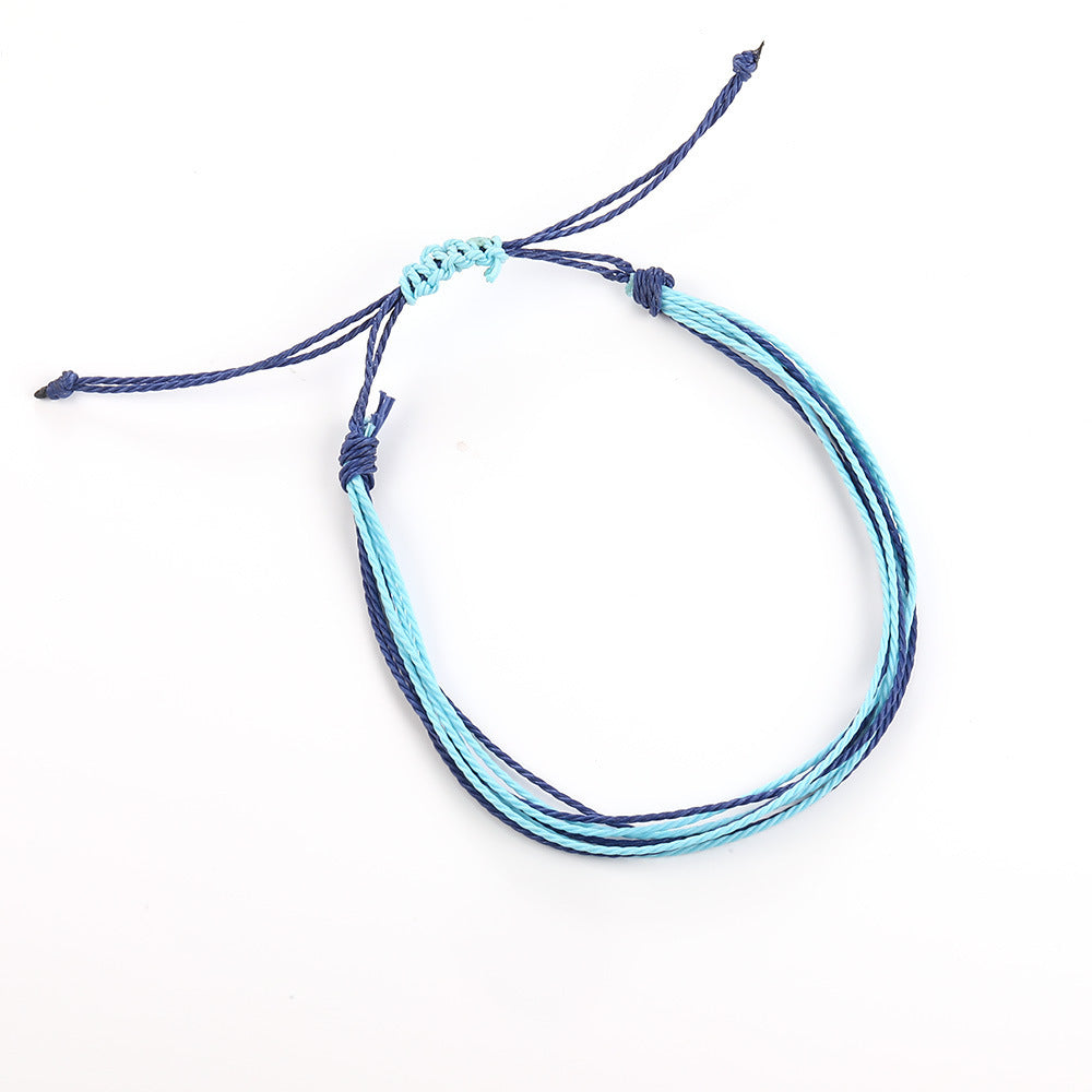 Multistrand bracelet with blue and black cords on a white background