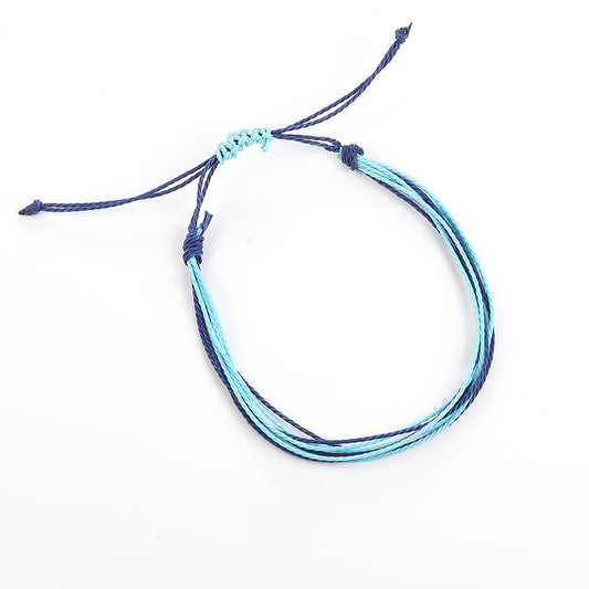 Multistrand bracelet with blue and black cords on a white background