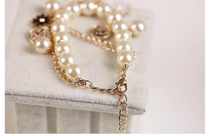 Pearl necklace with gold chain on a light gray background