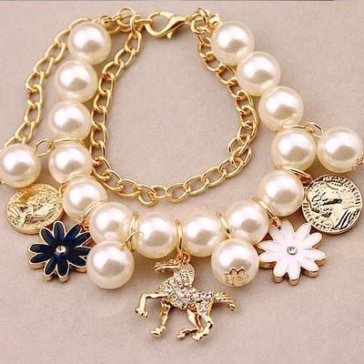 Multistrand bracelet with pearls, flowers, and unicorns on a beige background