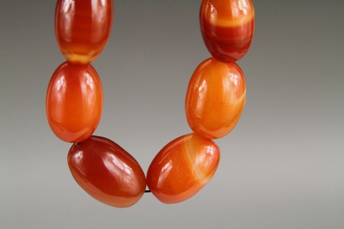 Necklace with orange beads on a gray background