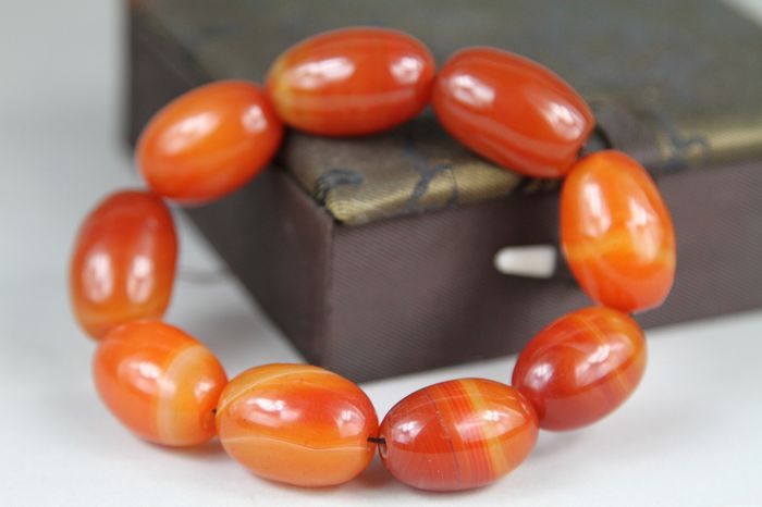 Orange beaded bracelet on a white background
