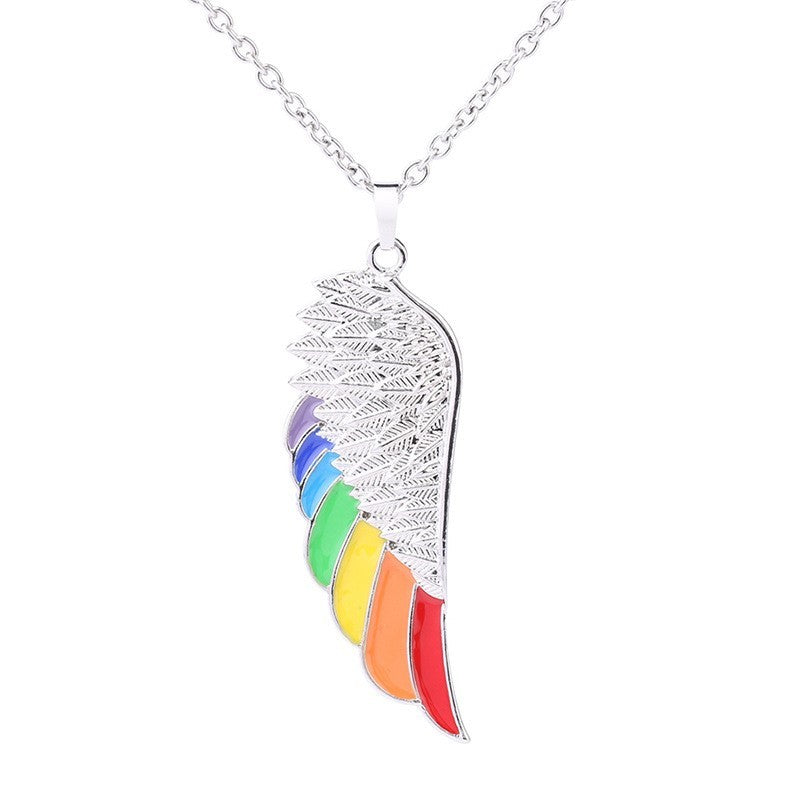 Necklace with a rainbow-colored wing pendant on a white background