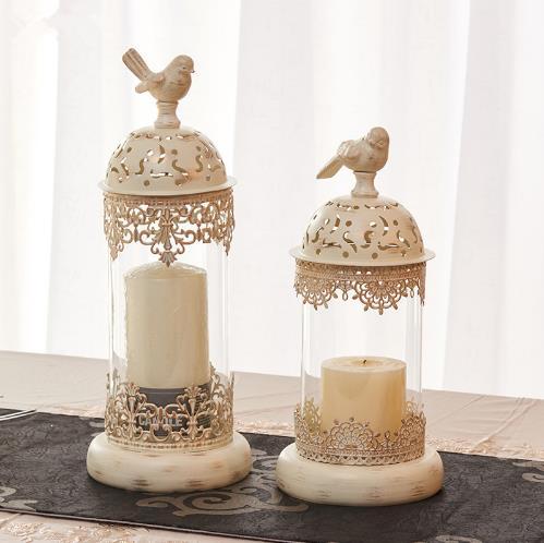 Two decorative candle holders with intricate designs on a neutral background
