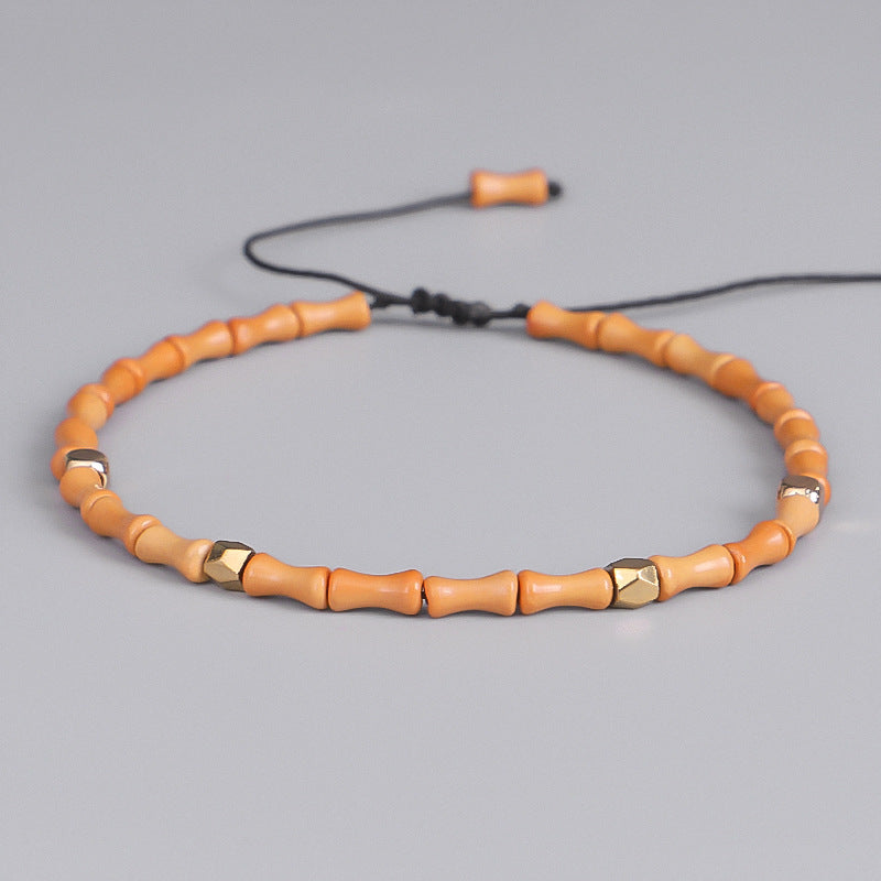 Necklace with orange beads and gold accents on a gray background
