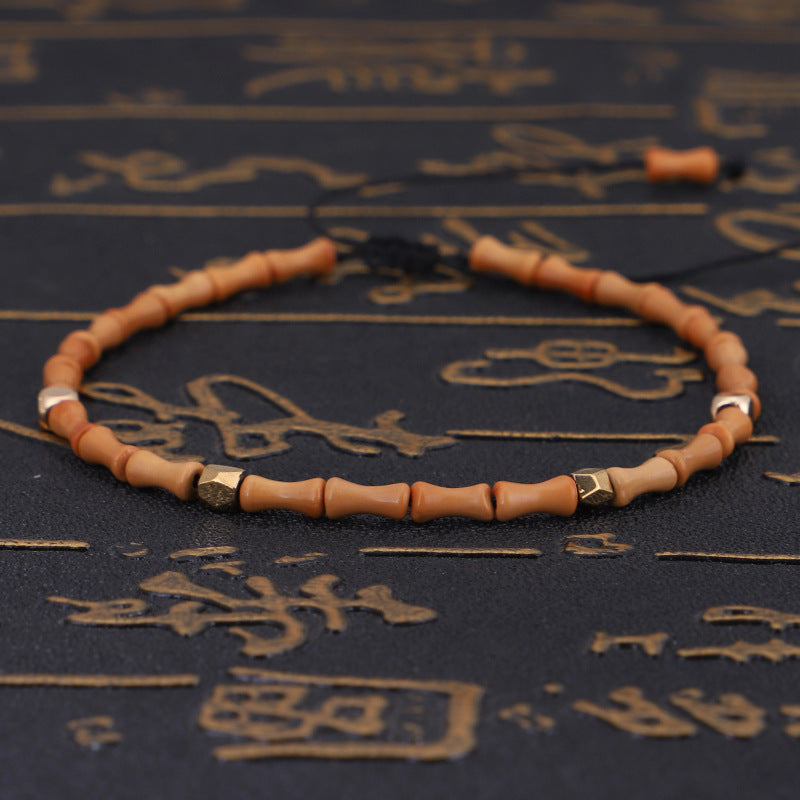 Beaded bracelet on a dark surface with engraved text