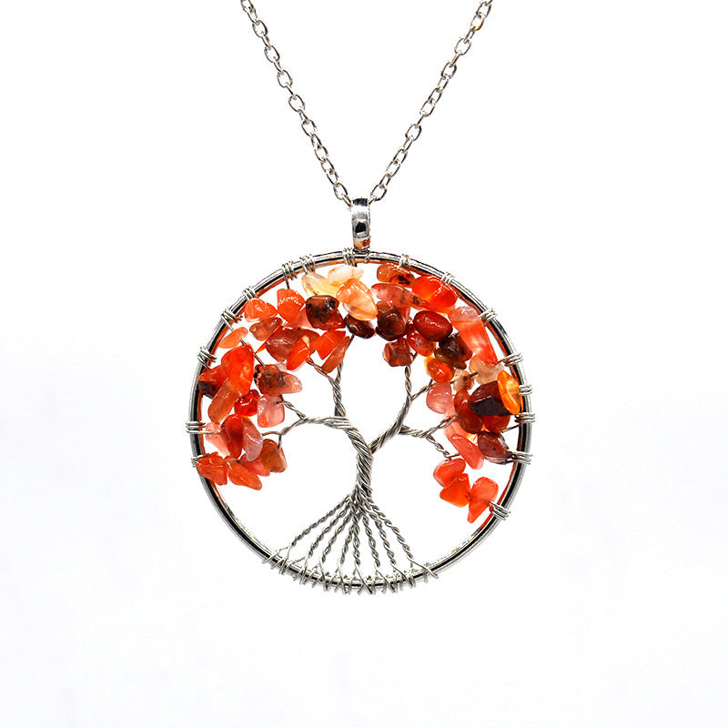 Tree-shaped pendant with orange and red stones on a white background