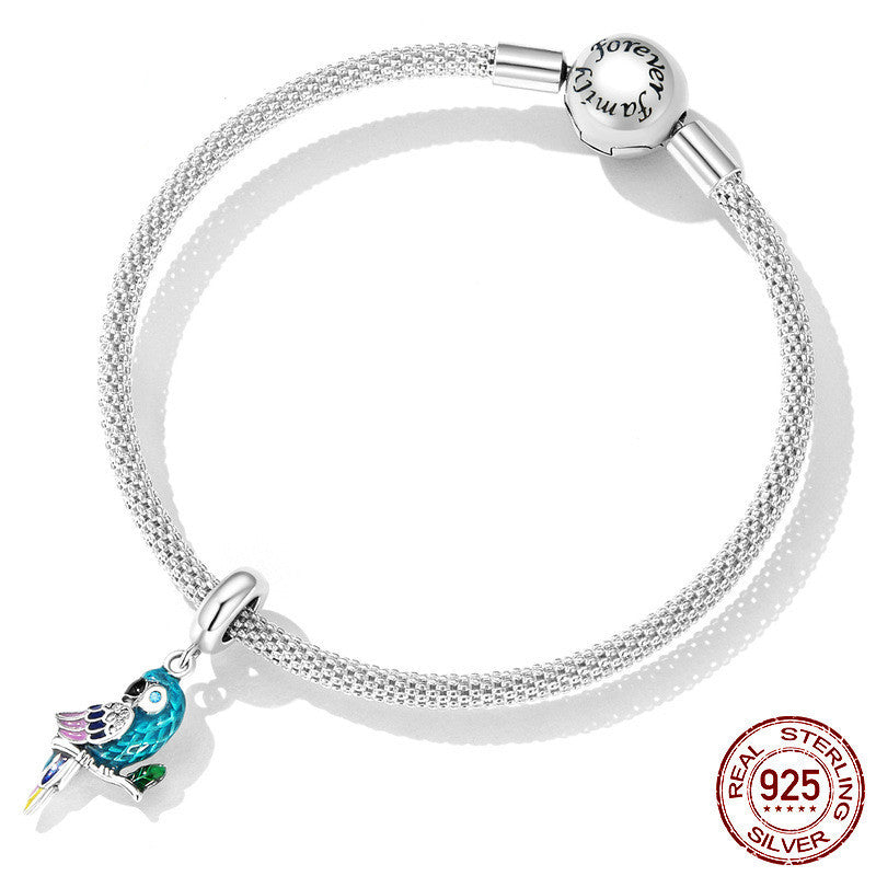 Silver bracelet with a bird charm on a white background