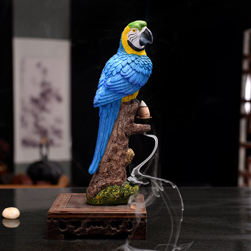 Blue parrot incense burner on a branch with smoke effect against a dark background