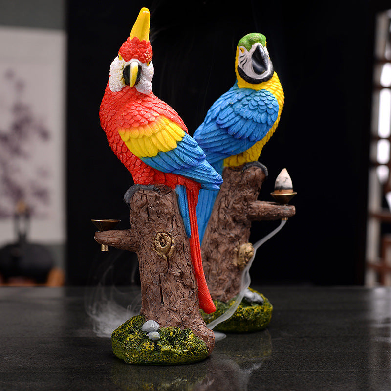 Colorful parrot incense burner on a wooden branch with a dark background