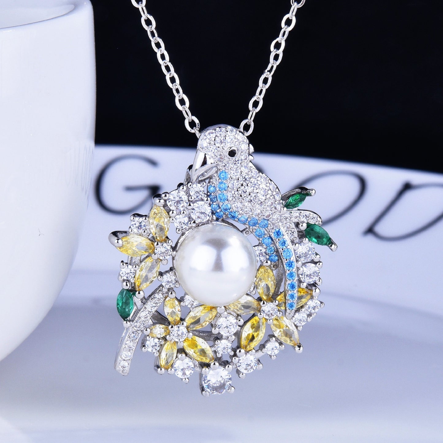 Pearl necklace with colorful gemstones on a white surface