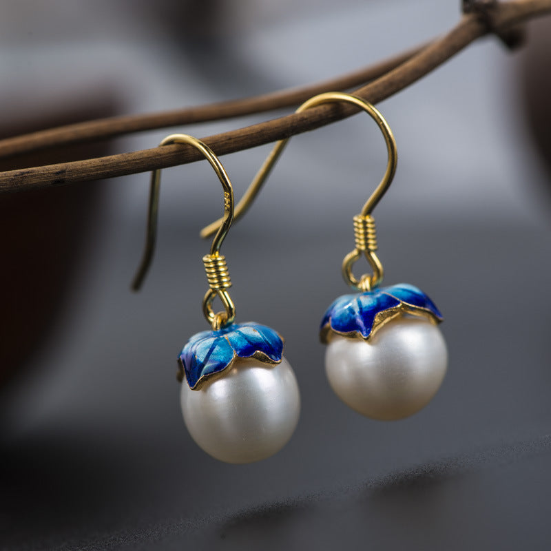 Pearl earrings hanging on branch