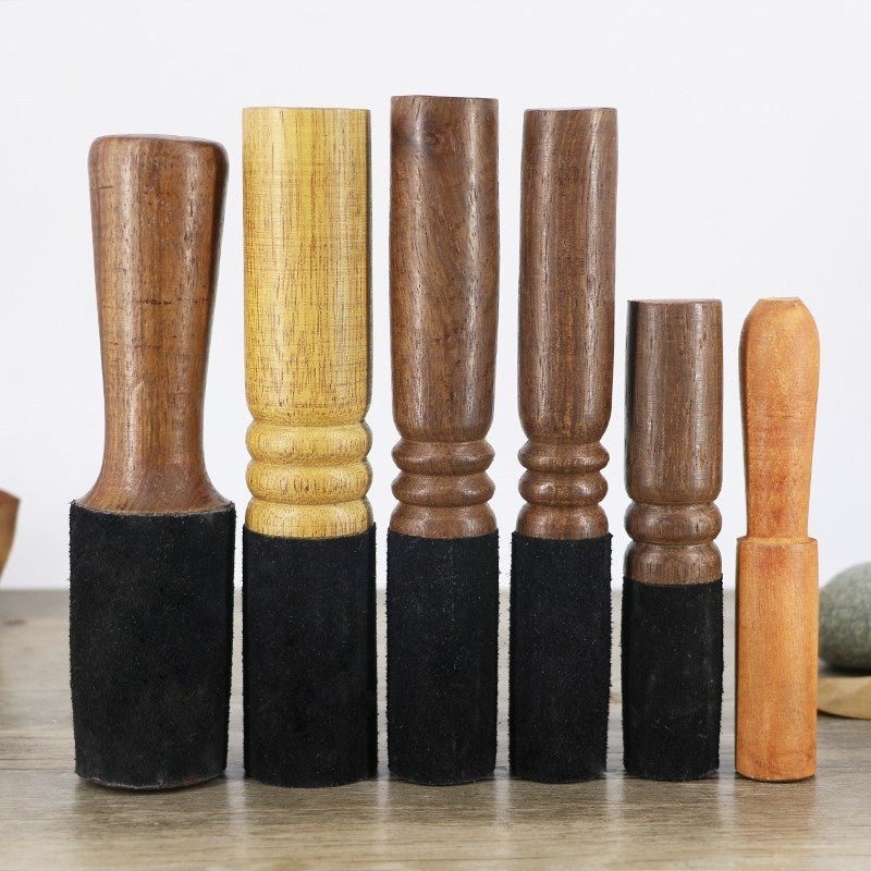 Set of wooden furniture legs with black felt pads on a light background