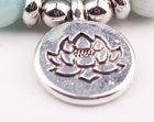 Silver lotus flower charm with 'Buddha' text on a white background