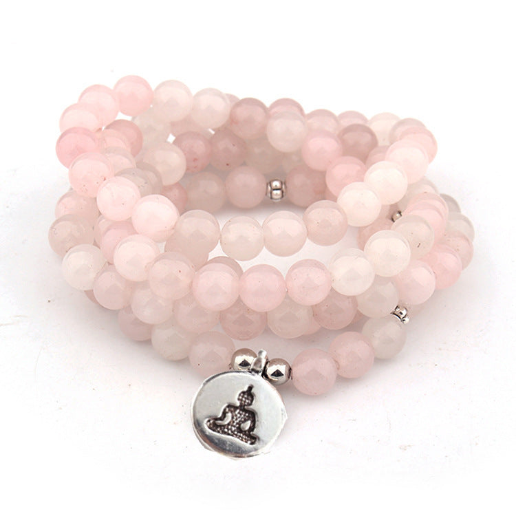 Stack of pink beaded bracelets with a silver Buddha charm on a white background