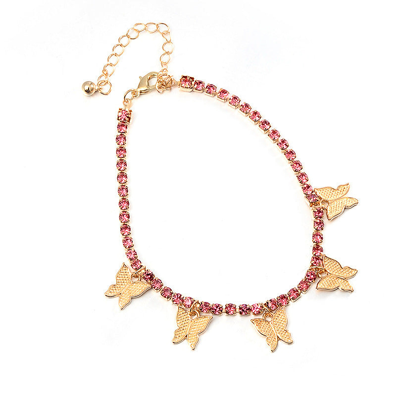 Bracelet with pink gemstones and gold butterfly charms on a white background
