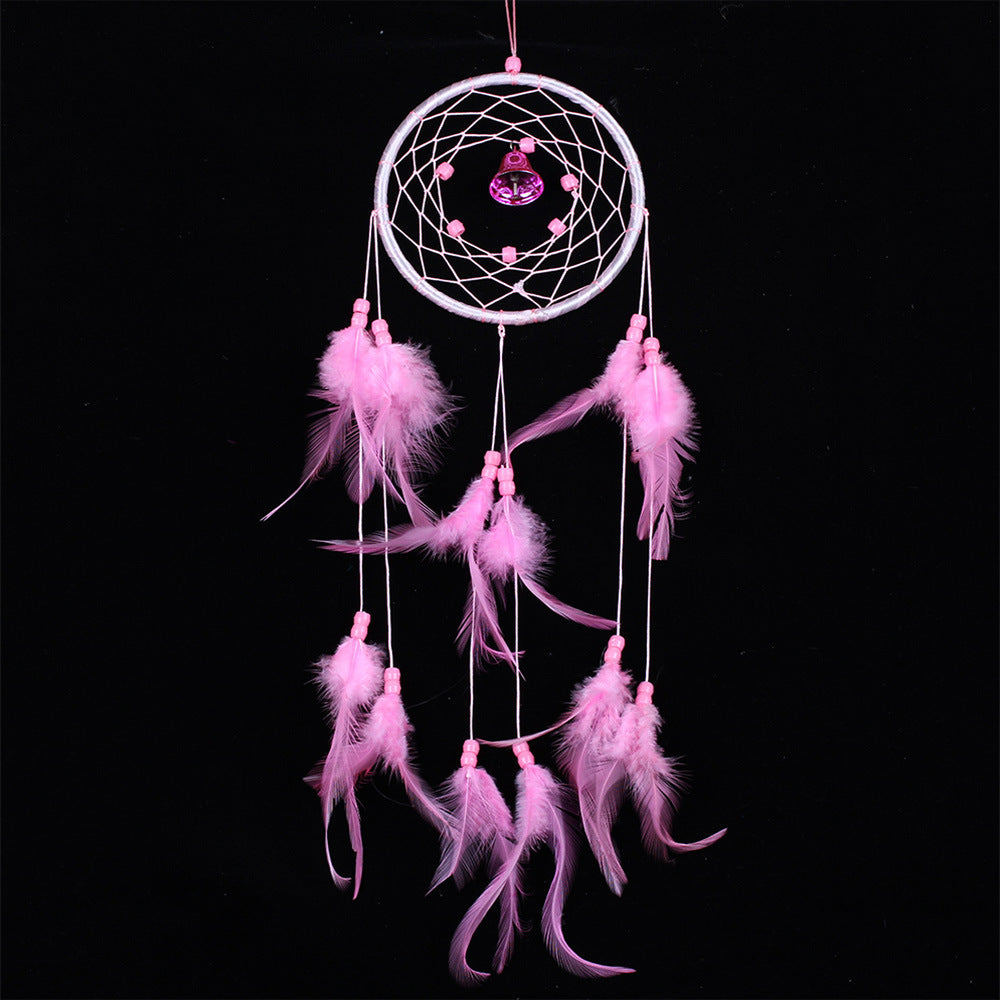Pink dreamcatcher with feathers on a black background