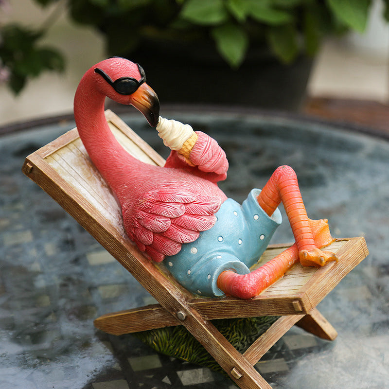 Flamingo figurine smoking a cigarette on a deck chair with a blurred background