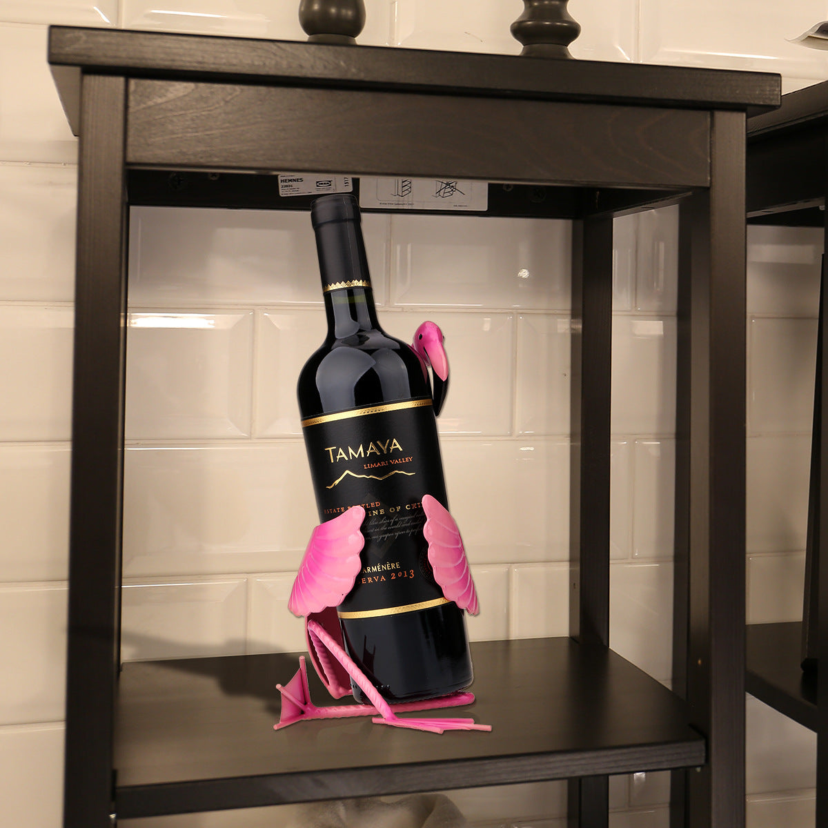 Bottle of Tamaya wine with pink gloves on a wooden shelf.