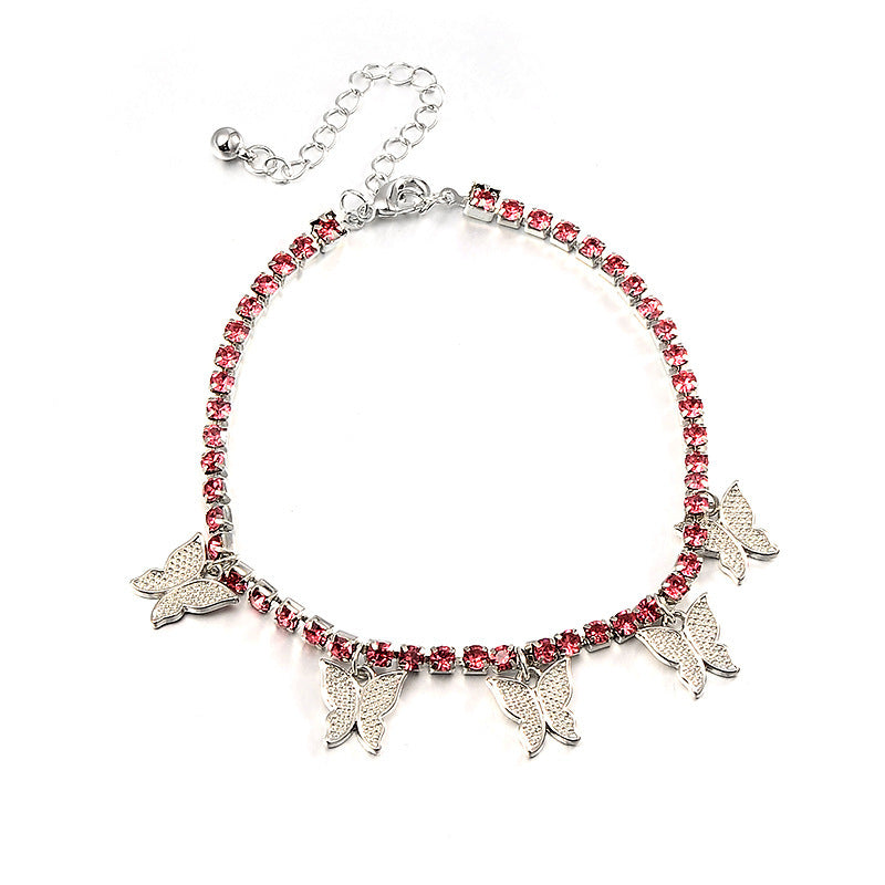 Bracelet with pink gemstones and silver butterfly charms on a white background