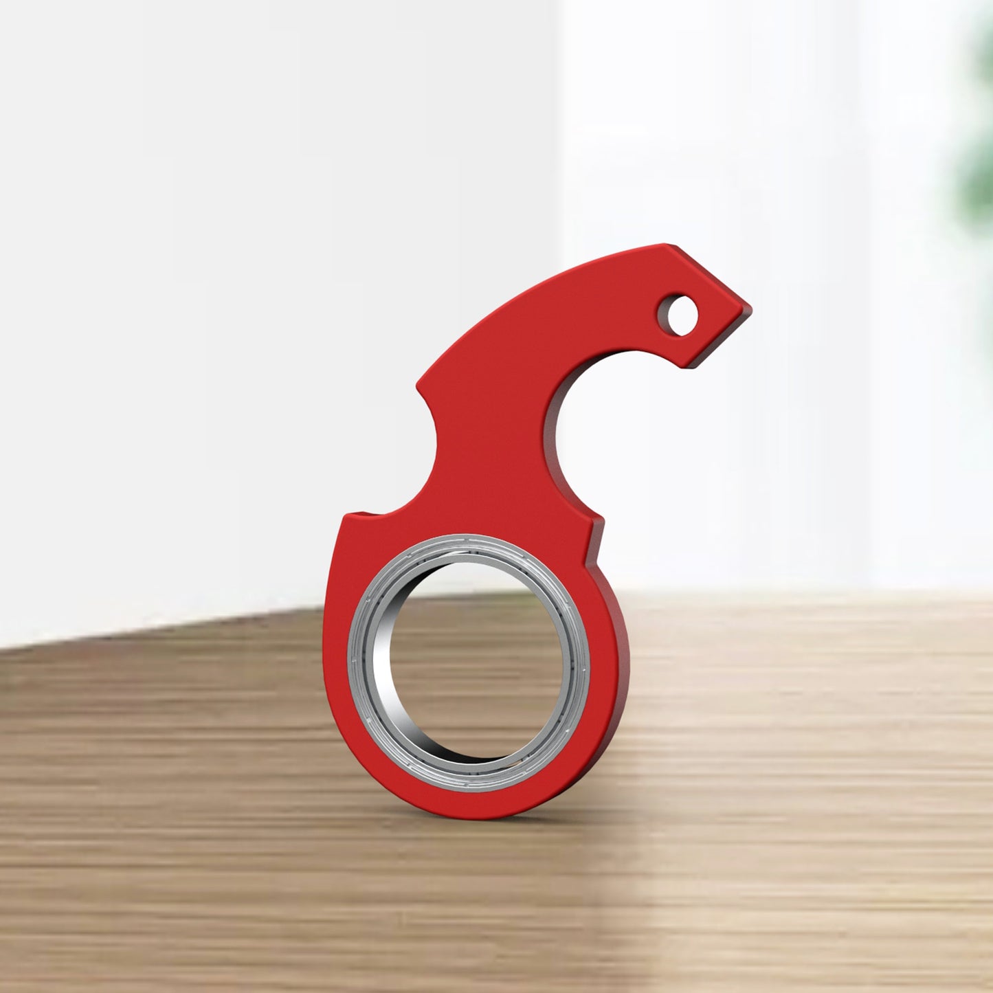 Red tool with a circular component on a wooden surface