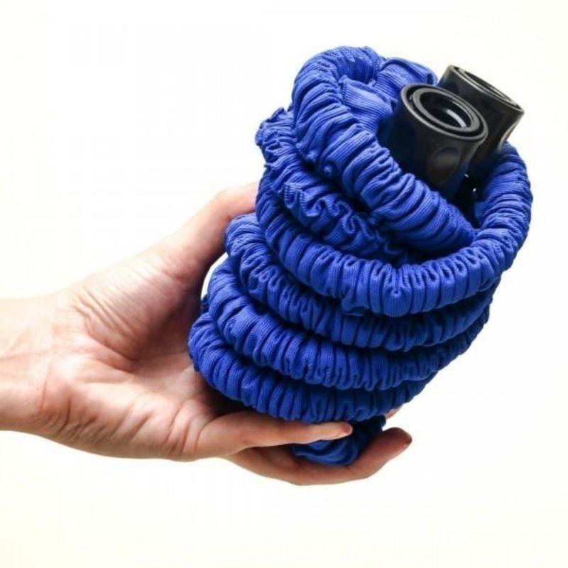 Blue expandable garden hose held by a hand against a white background