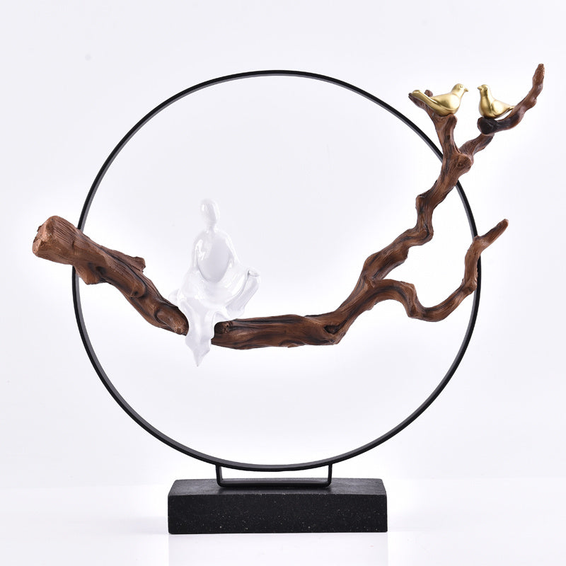 Decorative sculpture with branches and a black circular frame on a white background