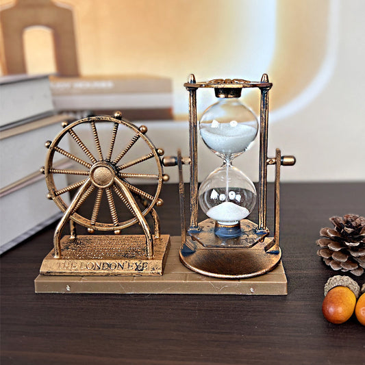 Decorative hourglass with a wheel on a wooden surface