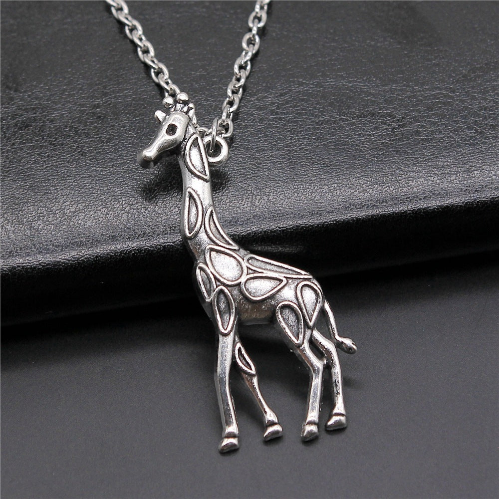 Silver giraffe pendant necklace on a dark surface