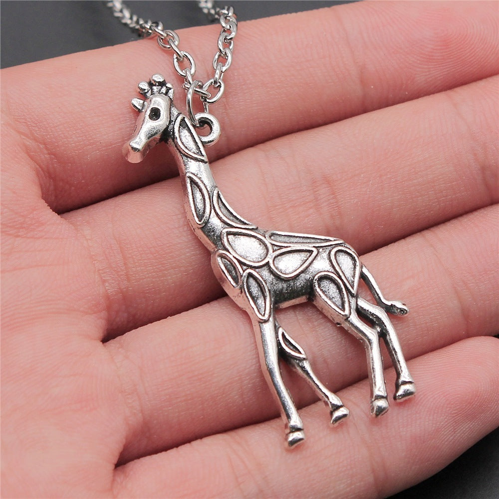 Silver giraffe pendant on a chain held in a hand