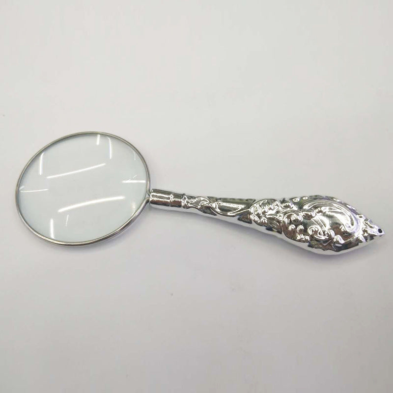 Silver-handled magnifying glass on a white background