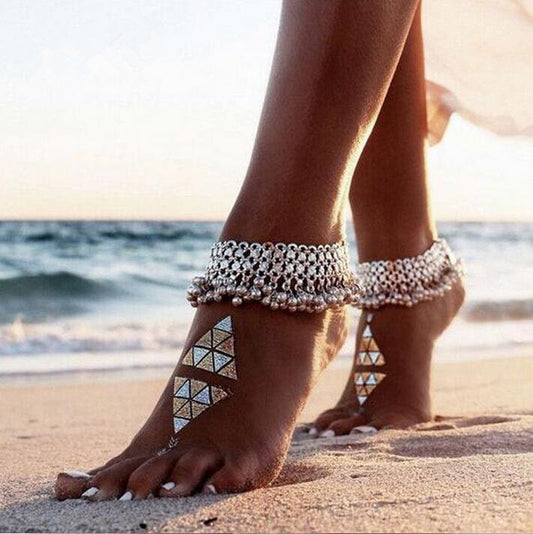 Feet with anklets on a beach