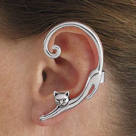 Silver cat-shaped ear cuff worn on an ear