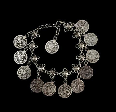 Silver bracelet with coin charms on a black background