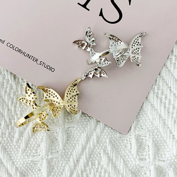 Butterfly-shaped earrings on a textured surface with 'COLORHUNTER_STUDIO' branding.