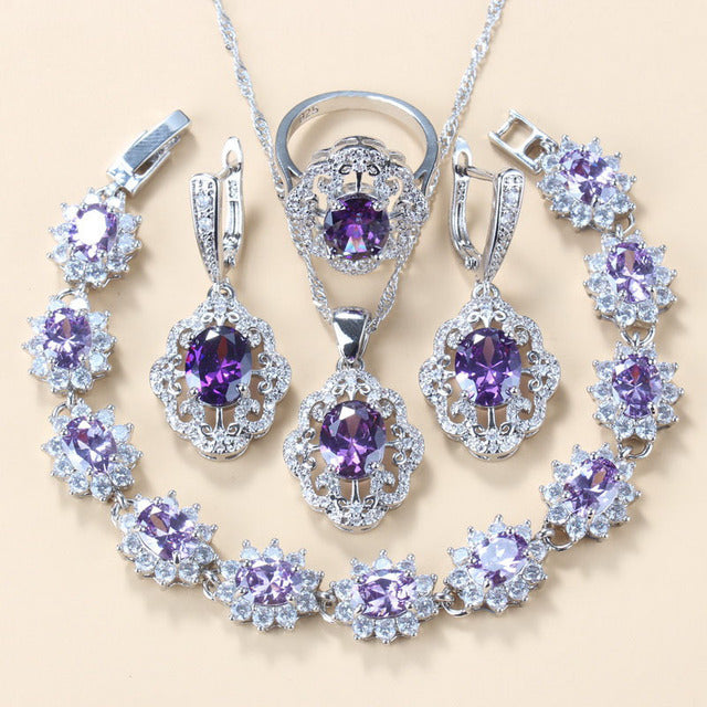 Jewelry set with purple gemstones on a beige background