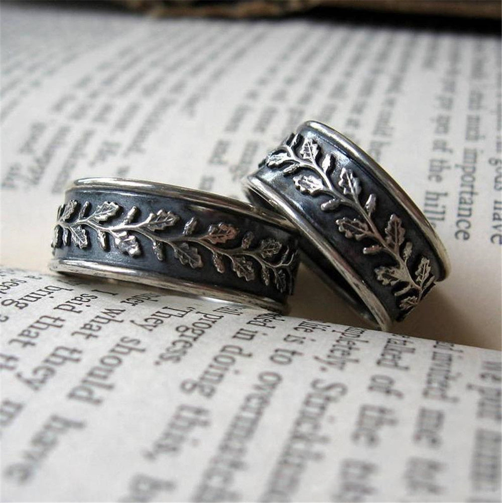 Two silver rings with floral designs on an open book