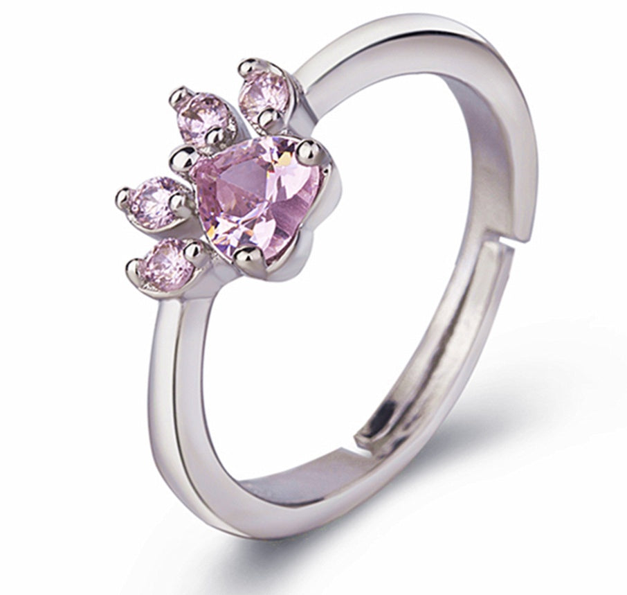 Silver ring with pink heart-shaped gemstone on a white background