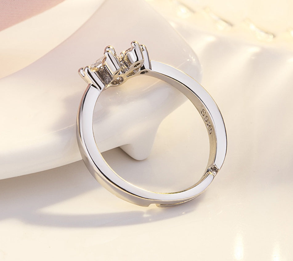 Silver ring with a diamond on a white surface