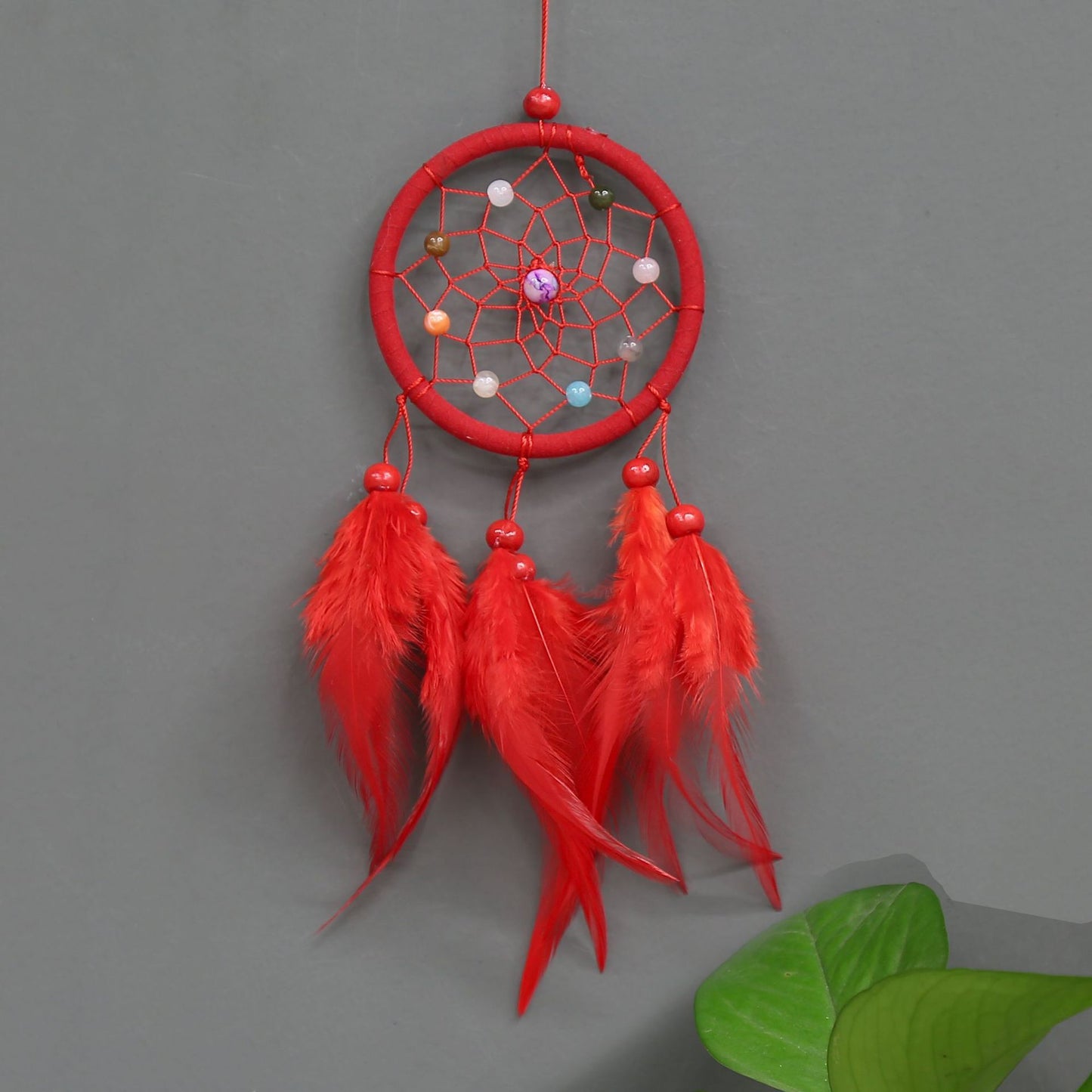 Red dreamcatcher with feathers on a gray background