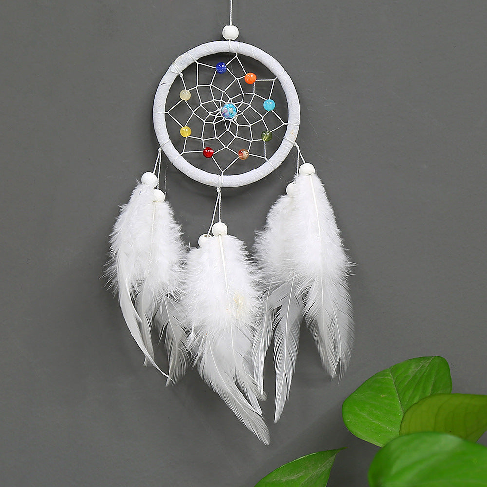 White dreamcatcher with feathers on a gray background