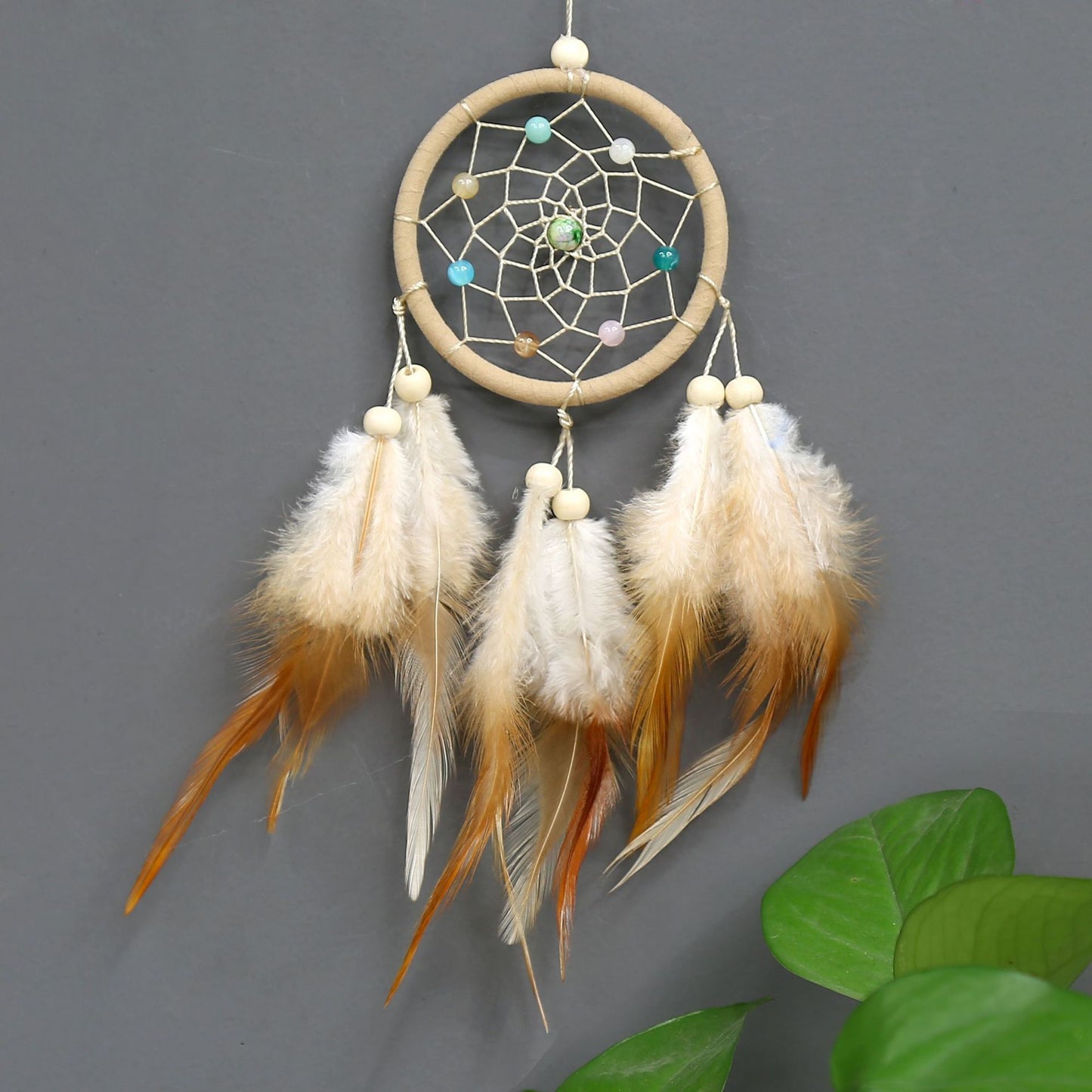 Dreamcatcher with feathers on a gray background