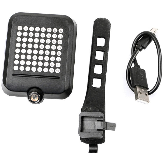 “Rear bike light, mount strap, and USB charging cable laid out”